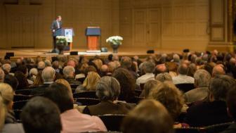 view of the audience from the back at the Boston Speaker Series in Boston Symphony Hall.