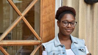 Chaurice Miller stands outside near a window