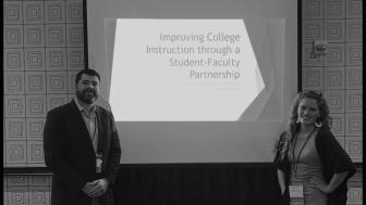 Frank Daniello and Caroline Acquaviva stand in front of a room with a powerpoint presentation on a screen behind them.