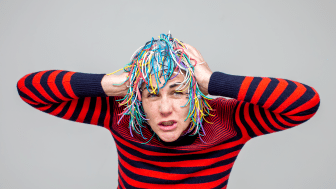 Eileen Powers in a striped shirt and one of the "heads" she and her collaborators designed.