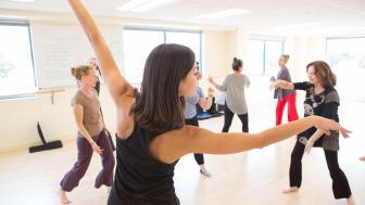 Students dance in a brightly lit studio.