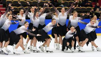 The Haydenettes - in costume on the ice. Hands out and smiling for group picture.