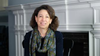 President Janet Steinmayer is wearing a scarf and dark sweater and smiling.
