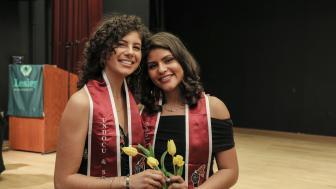 Jeannine Hernandez and Vita Franjul wearing the crimson stoles each graduate received