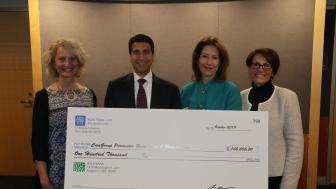 Photo of four people holding a large check from New York Life Foundation for $100,000.