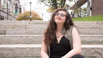 Jess Rizkallah sits on steps at Lesley University.