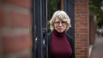 Photo of Jill Lepore standing in Harvard University gates