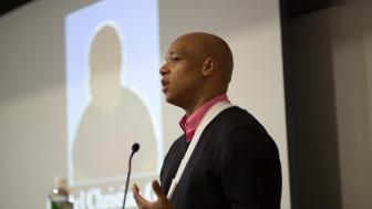 Joel Christian Gill speaks while standing at a podium.