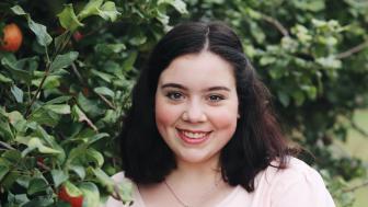 Julia Caruso standing next to an apple tree