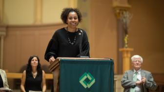 Maritsa Barros speaks at a podium in the church.