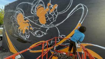 Michael Talbot works on his East Somerville mural "Artisanal."