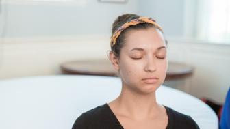 Young woman meditating with eyes closed