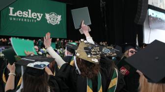 A view of the graduates in the audience with the Lesley banner in the background.