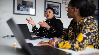 Myisha Rodrigues working with colleagues at a shared desk