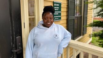 Redempta "Demi" Muhorakeye pictured in front of the yellow 82 Oxford St building on the Lesley campus.