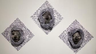 Three sculpted masks on a wall