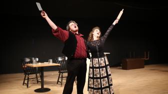 Two students are singing on the stage.