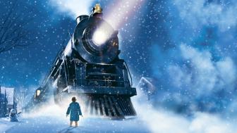 Image of boy in front of train in the snow.