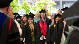 graduates greet people during commencement