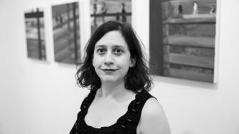 B&W photo of Azadeh Tajpour in front of her artwork