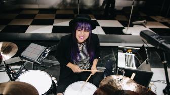Drummer and Lesley alum Caitlin Kalafus sitting at her drum set.