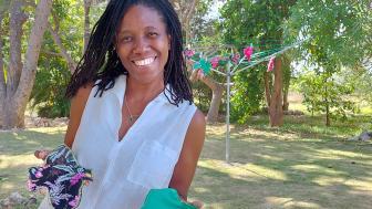 Cherith Pedersen standing outside holding two handmade menstrual pads