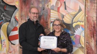 Michael O'Connor (left), the mayor of Frederick, Maryland, is pictured with Cynthia Scott during the ribbon-cutting event at Gaslight Gallery. Leigh Cortez's artwork is in the background.