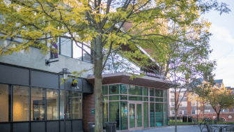 Outside photograph of the student center building on Doble quad with a green tree in front of it.