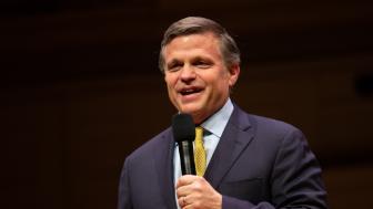 Douglas Brinkley holding a mic