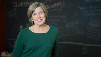 Nancy Carlsson-Paige standing in front of chalkboard smiling