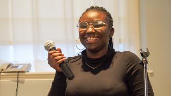 Photo of Nirmala Legale holding a mic and smiling