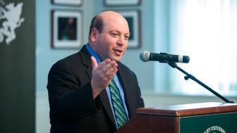 university president Jeff Weiss speaking at a podium