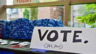 Voter registration table in the student center with signs and tshirts