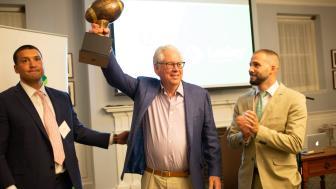 George Weiss holds up a bronze football jersey