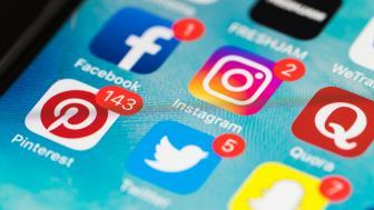 Close-up of a cell phone screen with social media icons displayed.