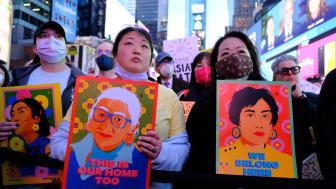 Stop Asian Hate Rally in Times Square - women holding images of asian people with words stop asian hate