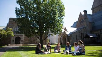 Students in an arc, chatting on Lesley's lawn.