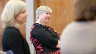 Sue Motulsky smiling between two people.