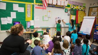 teacher teaching small children at a board
