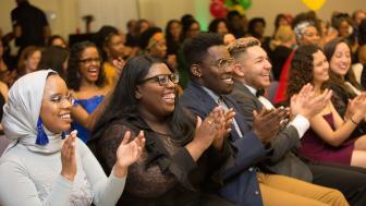 Students in an audience dressed up for the Unity Gala, applauding the award winners.