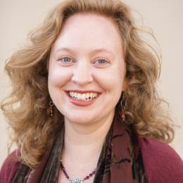 Photograph of Jena Leake smiling at the viewer from the shoulders up.
