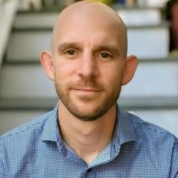 Headshot of Joe in a blue collared shirt