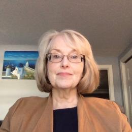 leadership phd programs massachusetts Valerie wearing a brown sweater in living room smiling for a photo
