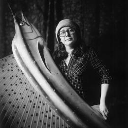 black and white photo of Jen Barrows holding a large plastic swordfish