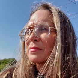 Photo of Cindy wearing glasses in front of a blue sky