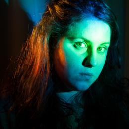 headshot of Christine Banna in front of green and orange lights