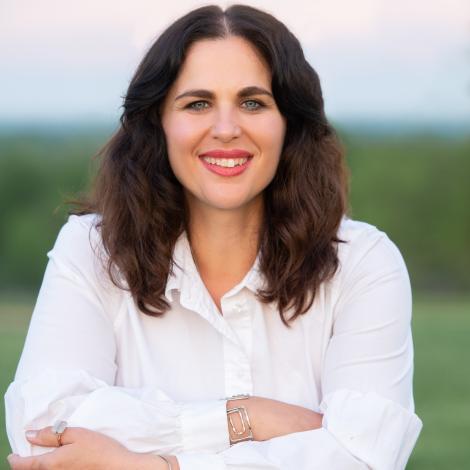 Headshot of Angelle Cook, sitting facing the camera smiling. 