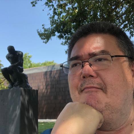 Brandon next to a statue looking off into the distance