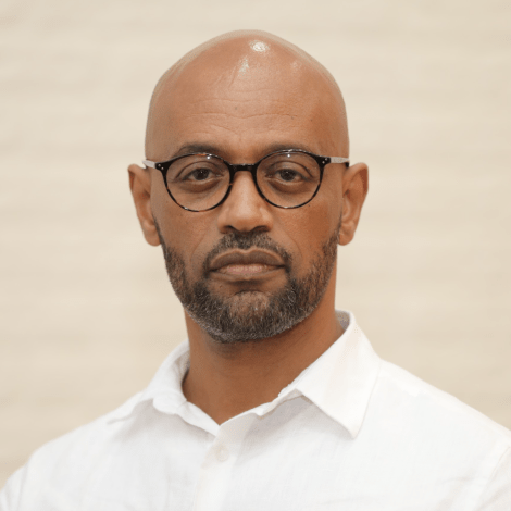 Photo of Fihisa Likke in a white collared shirt with a beige background