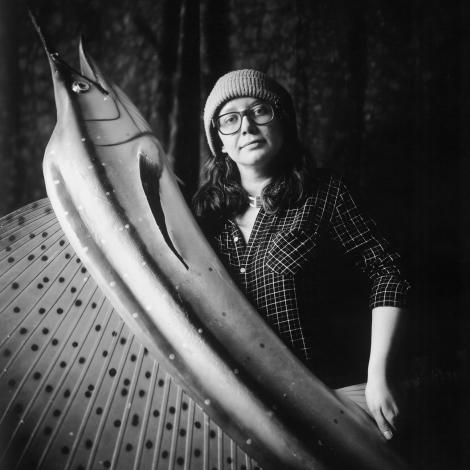 black and white photo of Jen Barrows holding a large plastic swordfish